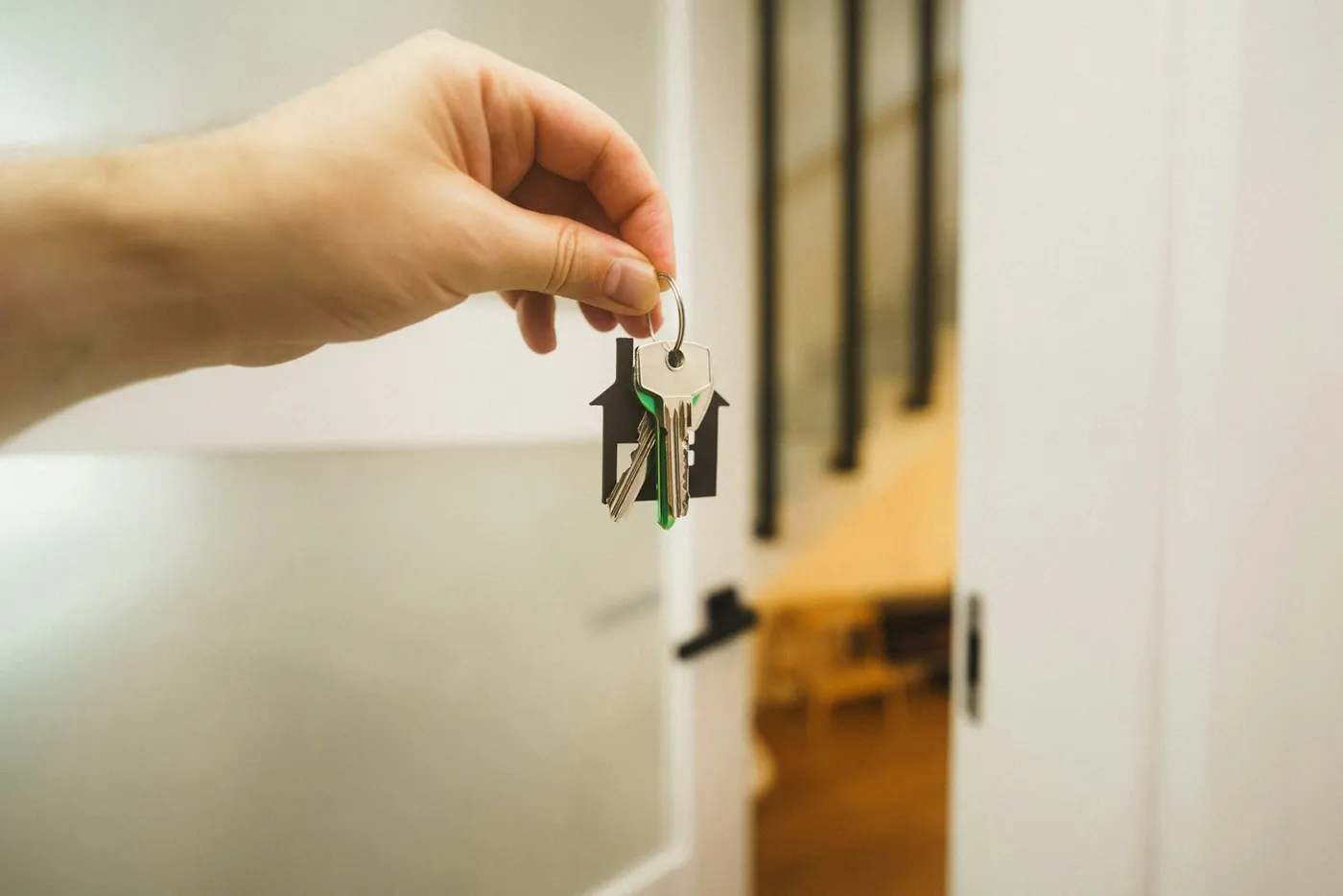 Mão segurando chave de imóvel quitado representando o crédito com garantia de imóvel CGI ou Home Equity