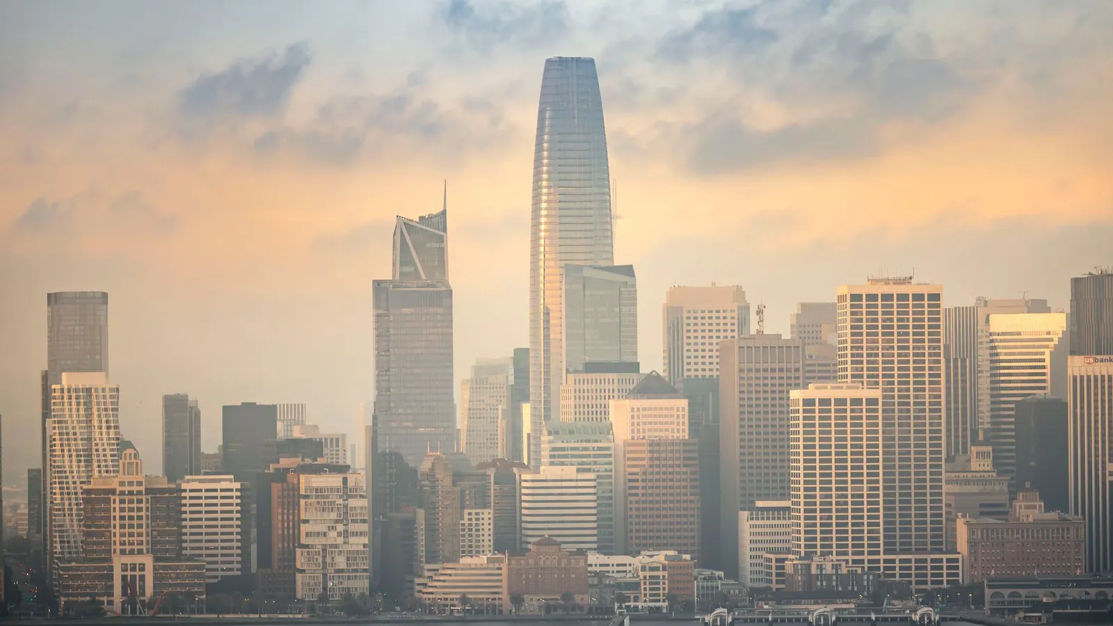 Torres de vidro de um distrito financeiro ao entardecer, com a luz dourada refletida nas fachadas, representando o conjunto de bancos, fundos de crédito e fintechs com quem a Credios negocia