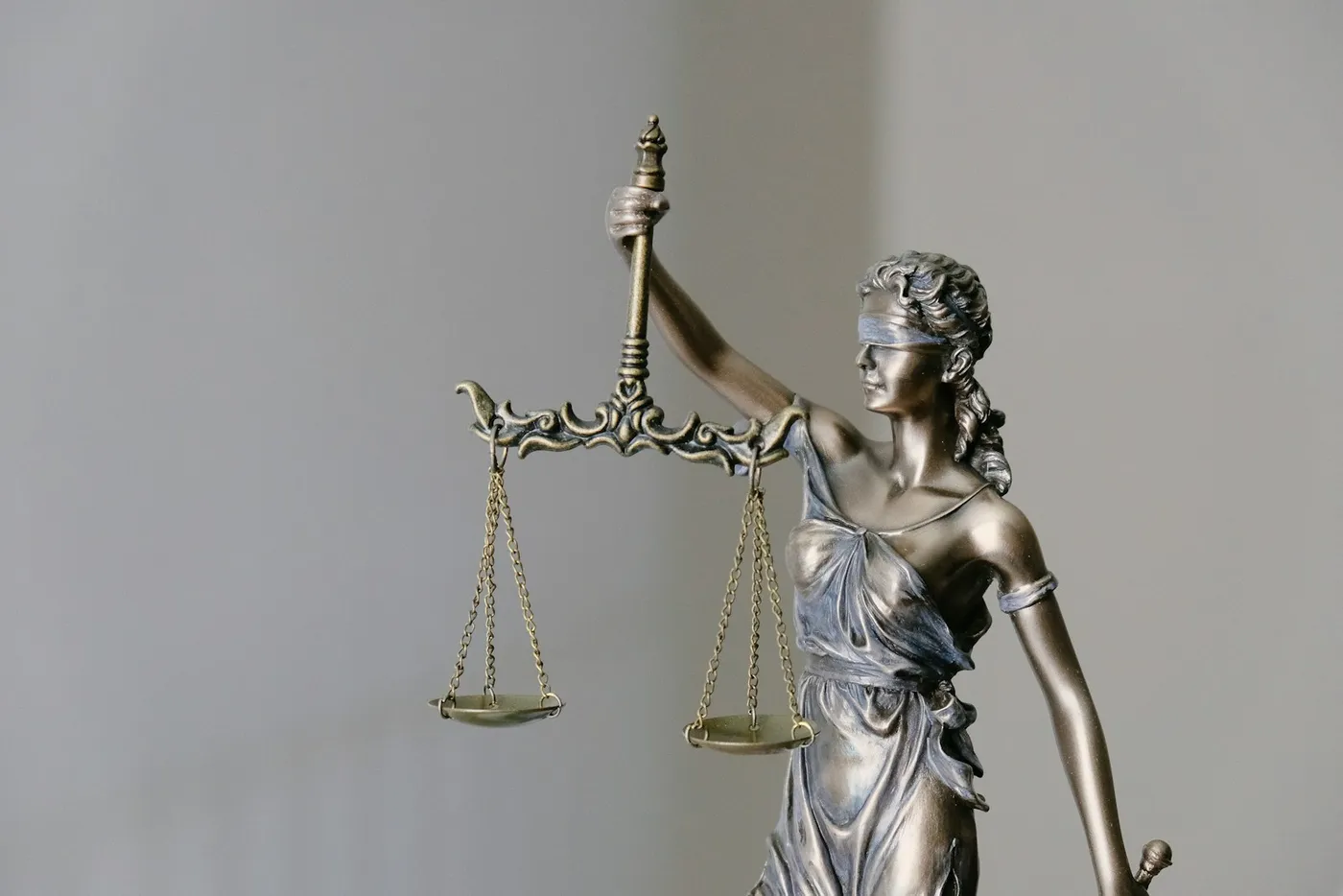 Estátua da Deusa da Justiça com balança e espada representando a execução extrajudicial prevista na Lei 9.514/97