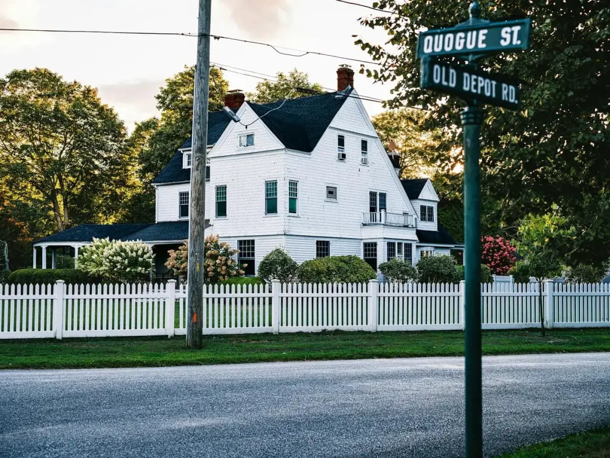 Casa branca americana de subúrbio com cerca picket fence representando o modelo de mortgage e deed of trust dos Estados Unidos
