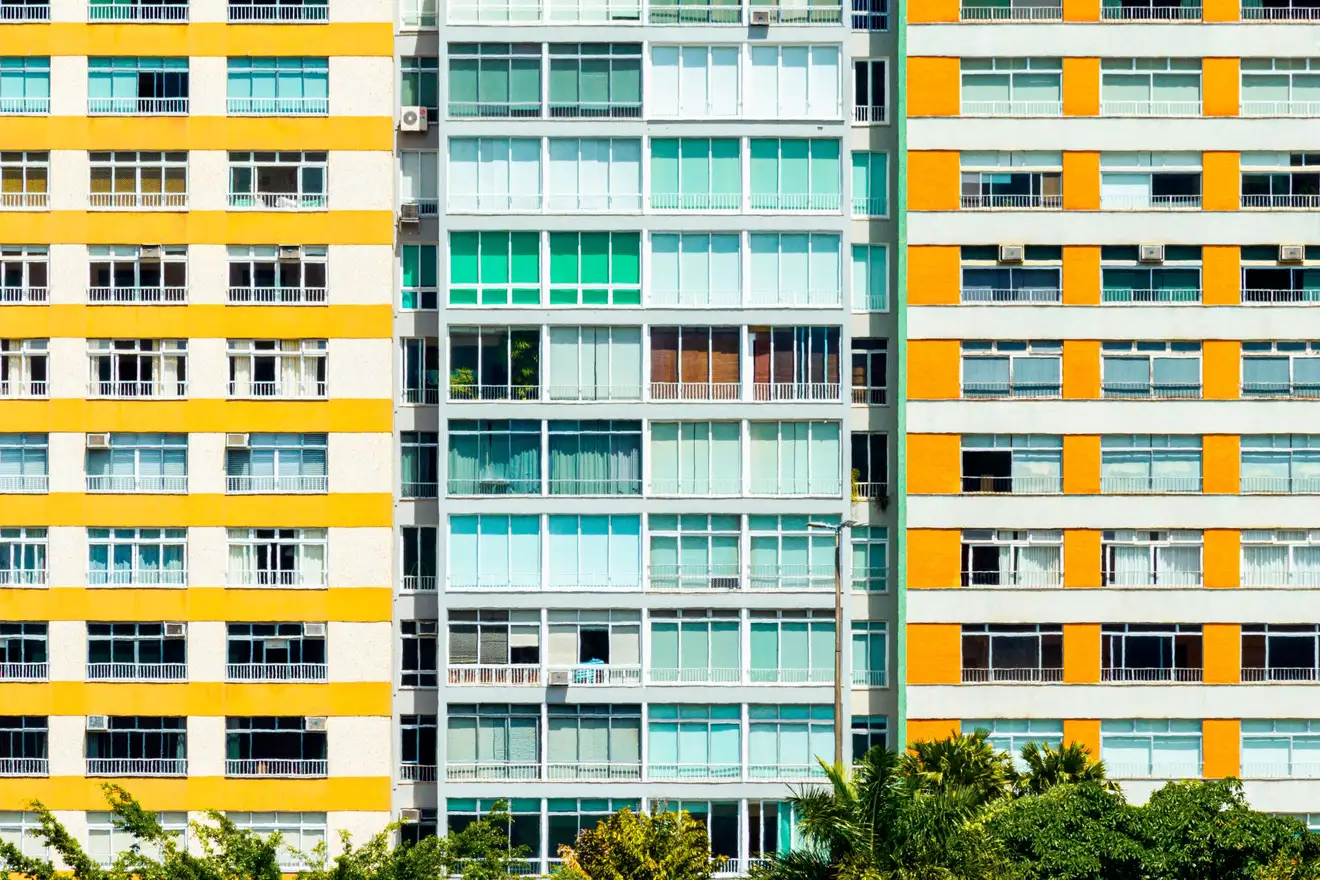 Fachada de prédio residencial modernista no Rio de Janeiro, com faixas amarelas e verde-água e fileiras de janelas