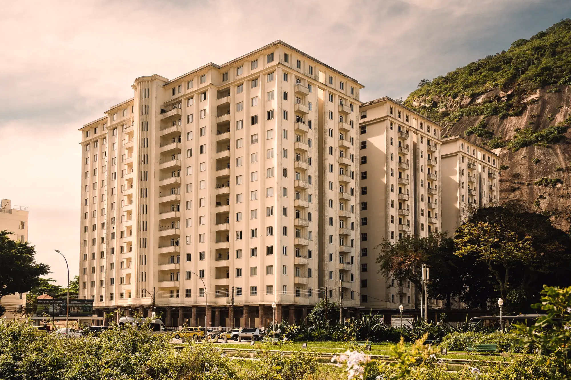 Condomínio residencial com jardim e morro verde ao fundo
